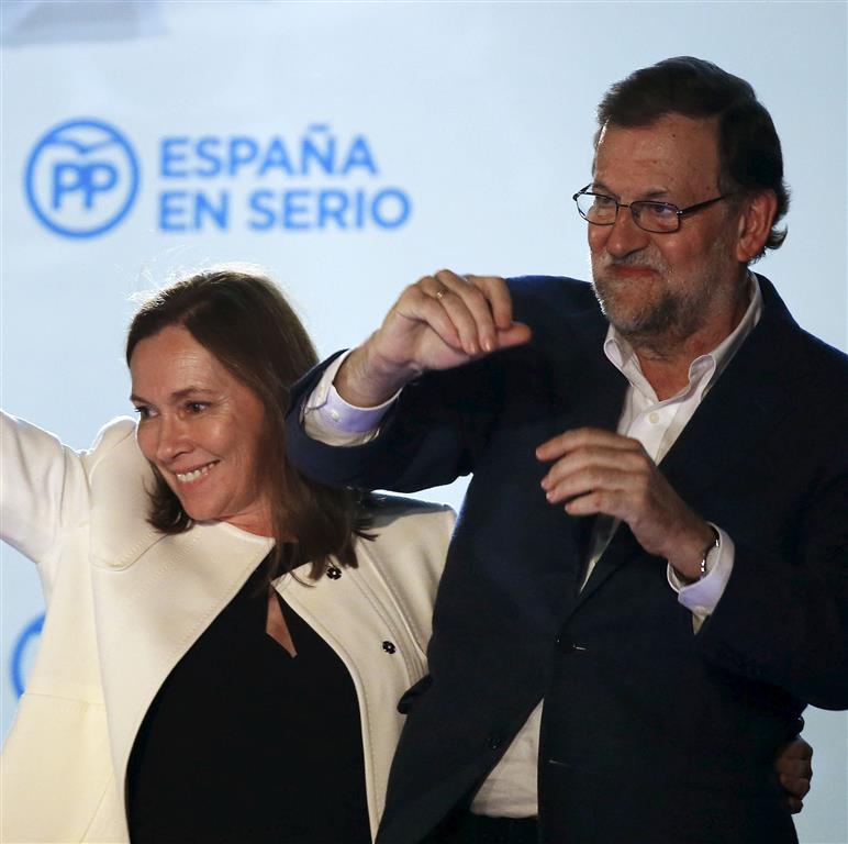 Spain’s Prime Minister and People’s Party candidate Mariano Rajoy gestures while addressing supporters next to his wife Elvira Fernandez after results were announced in Spain’s general election on Monday